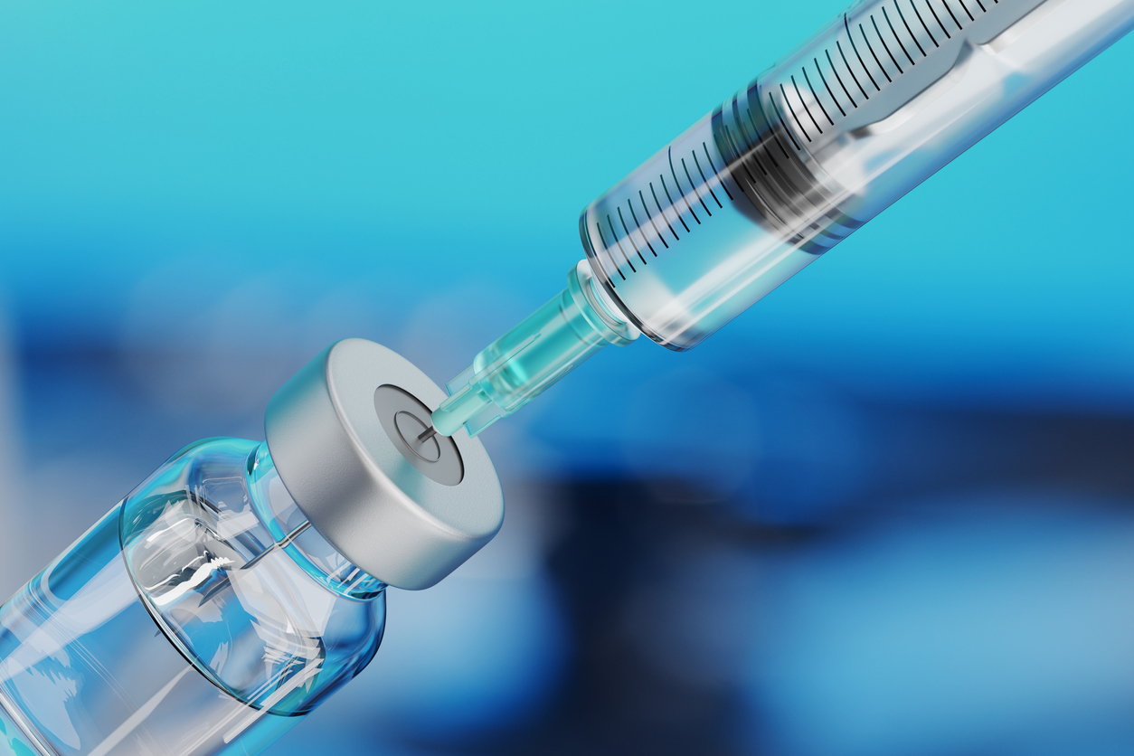 A syringe drawing fluid from a sterile vial