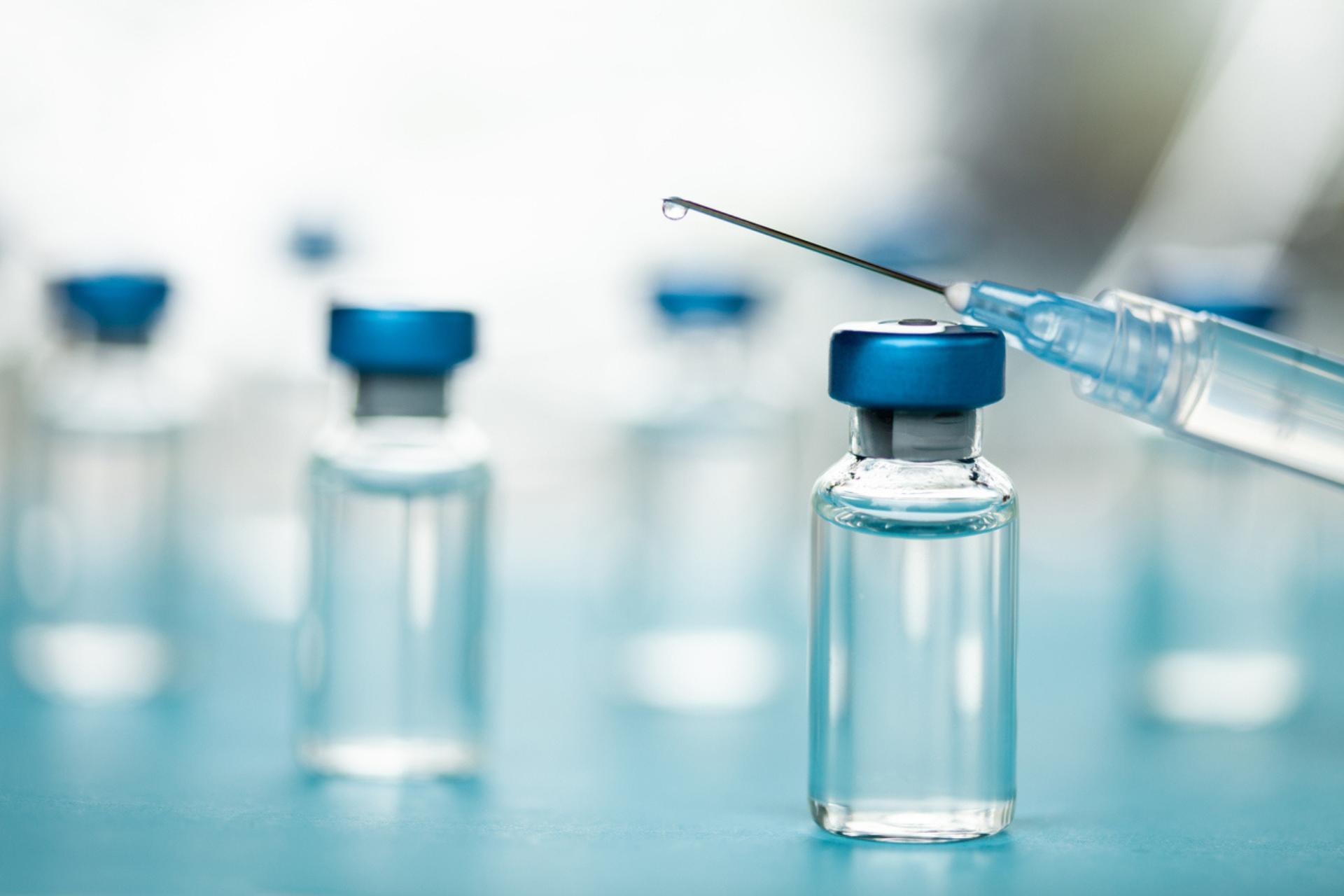 Sterile injectable manufacturing - Vials of injectable medication on a table with a syringe.