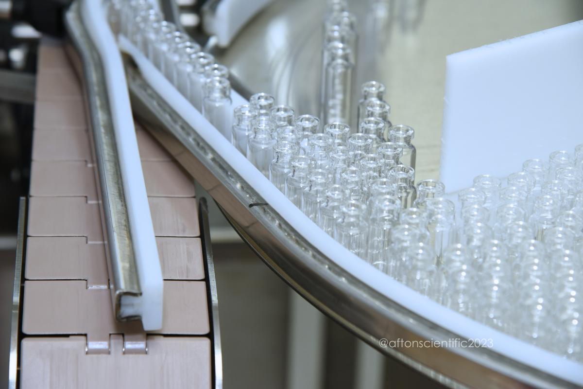 empty sterilized vials in a conveyor in a pharmaceutical cleanroom