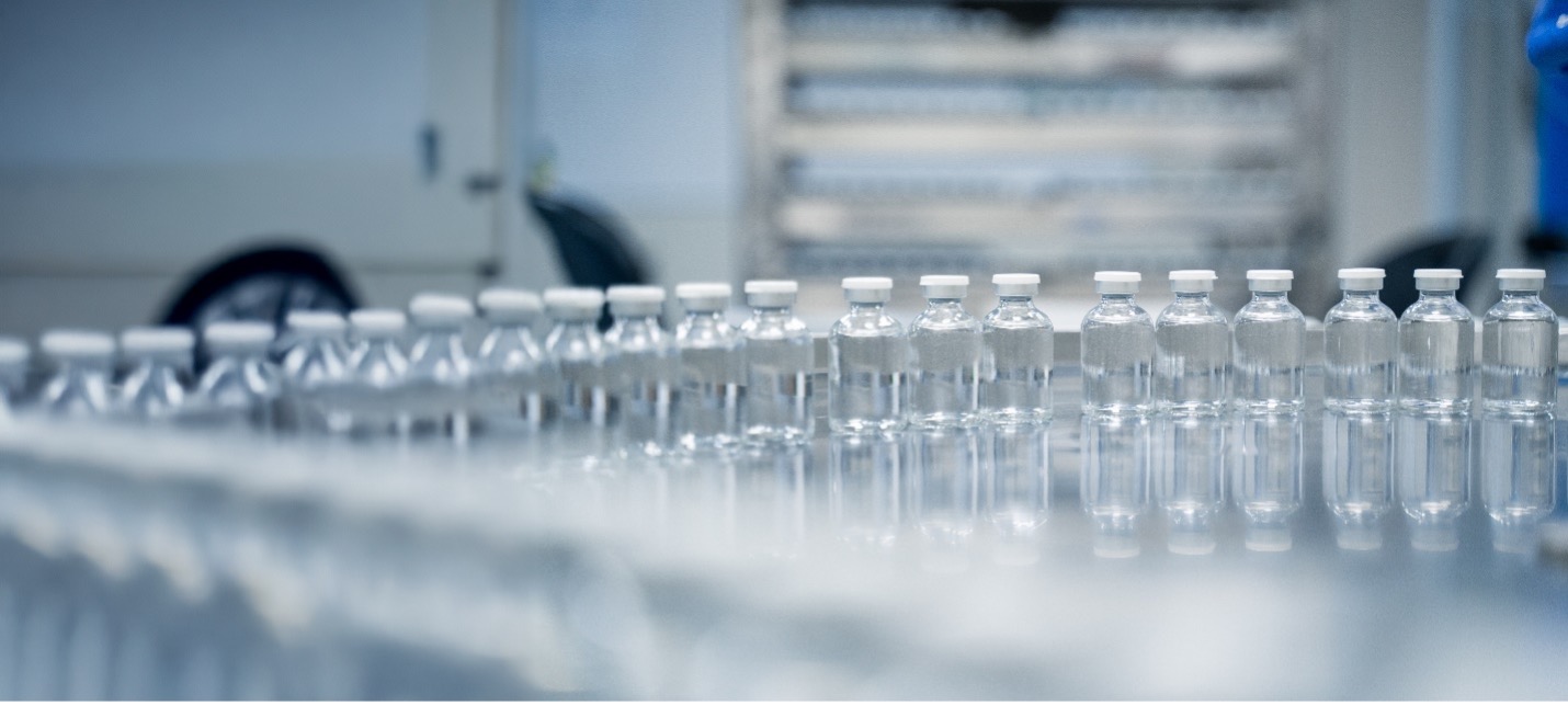A row of clear aseptically filled vials with stoppers and seals in a pharmaceutical ,manufacturing facility
